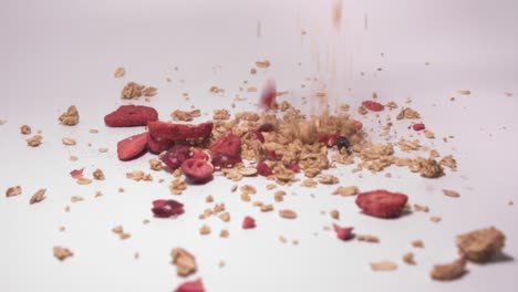 muesli mix falling on white surface - rolled oats with dried fruits