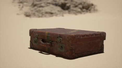 old leather suitcase in the desert