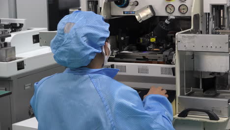 industrial professional female worker engineer in blue uniform operating modern machine using control tools in industry factory setting