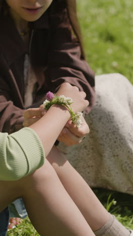 girl making a clover bracelet on a summer day