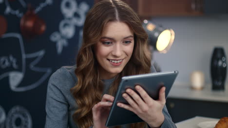 portrait of surprised woman getting good news on tablet computer in home office.