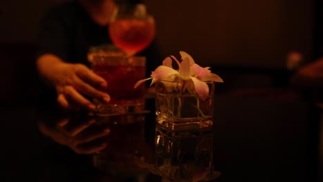 hands reaching for drinks with flowers