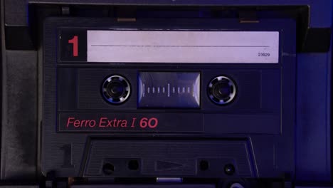 audio cassette tape playback in vintage deck player from 1980's, close up