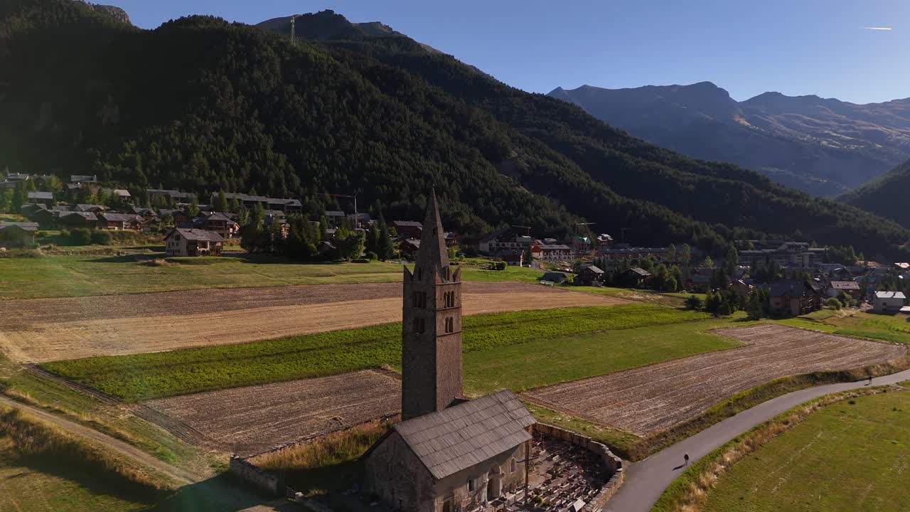 Drone, der flyver i cirkelbevægelser og filmer en kirke i en bjergdal i 4K