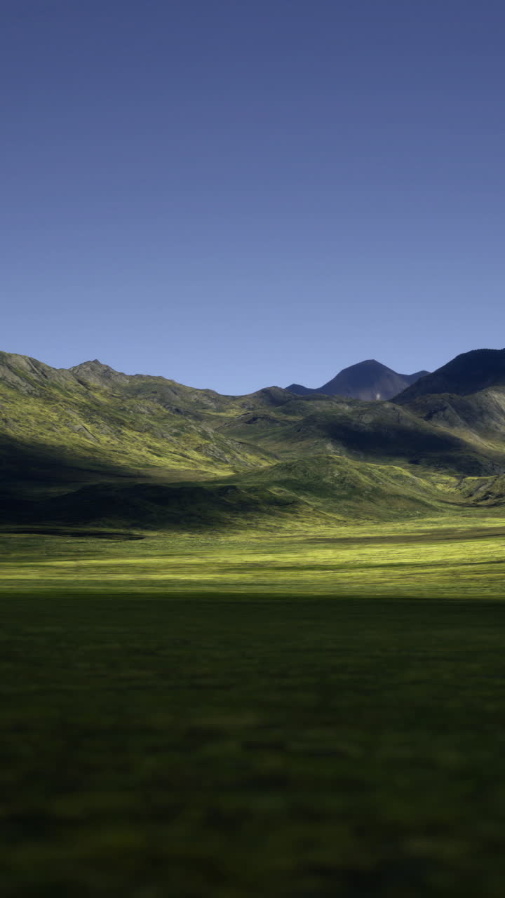 Maestose valli verdi e montagne sotto un cielo azzurro limpido all'alba.