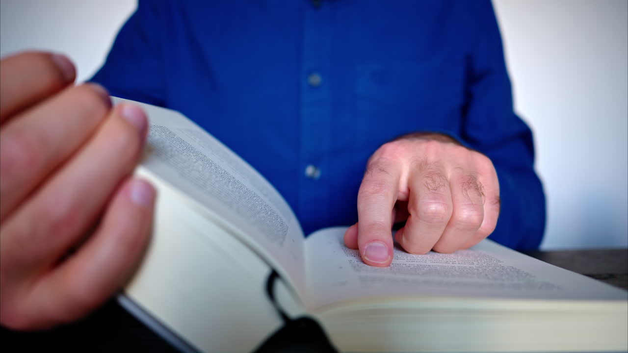 Close-up of a man reading a big book
