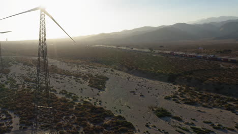 aerial view flying past huge wind turbines through the desert durning sunset near palm springs in the mojave desert, california, usa