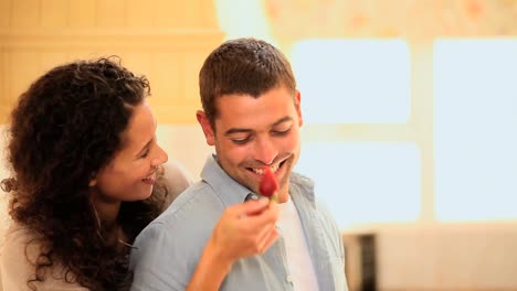 mujer burlándose de su novio con una fresa