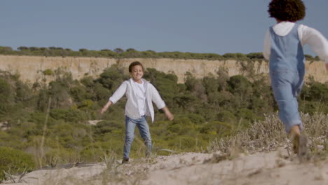 Kleines-Amerikanisches-Mädchen-Läuft-Und-Umarmt-Ihren-Bruder,-Während-Sie-An-Einem-Sonnigen-Tag-Die-Urlaubszeit-Im-Naturpark-Genießt