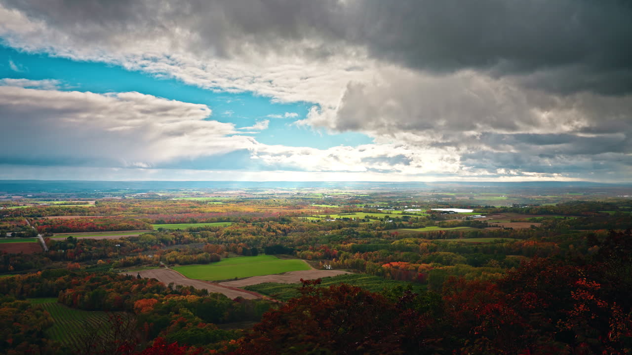 Picturesque landscape view of Nova Scotia, Canada from high view point. Vibrant Autumn colors. View of the rural, peaceful scenery. Dramatic sky, sun rays coming through the clouds.