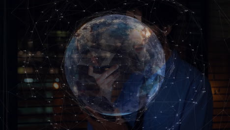 man holding smartphone manipulating earth globe, displaying network nodes and data for technology