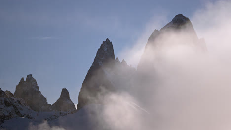 rugged mountain peaks rise above the clouds in a serene, misty landscape