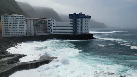 mesa del mar natural sea water pools with strong waves in tenerife canary islands spain, aerial dolly right shot
