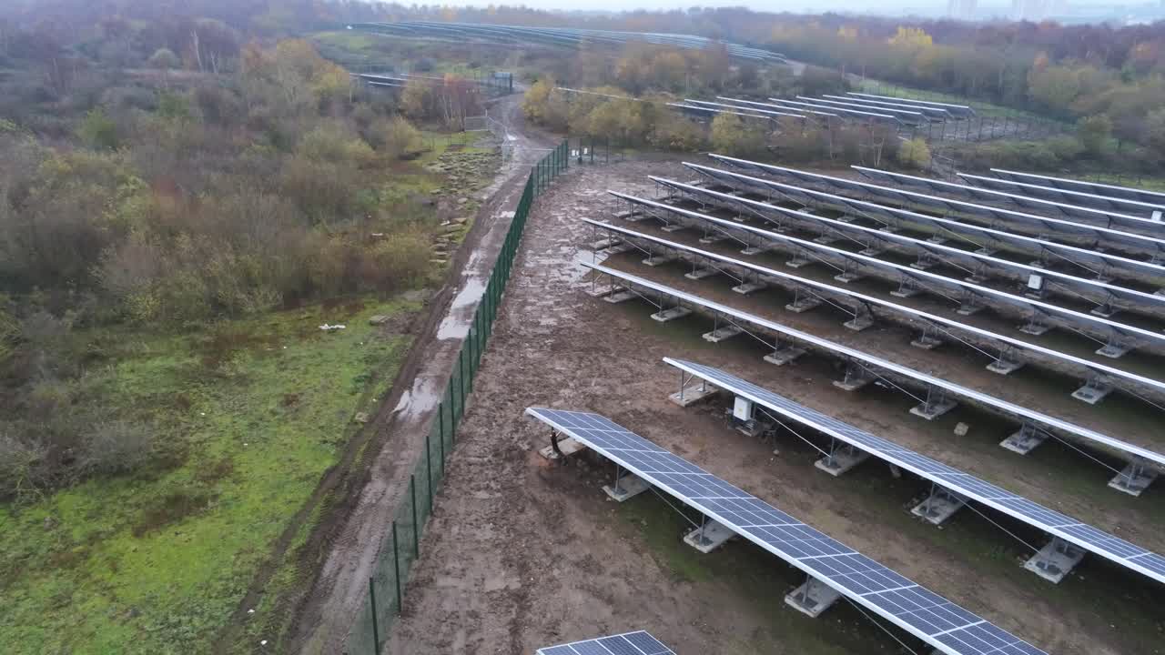 Solar panel array rows aerial view misty autumn woodland countryside pull back low