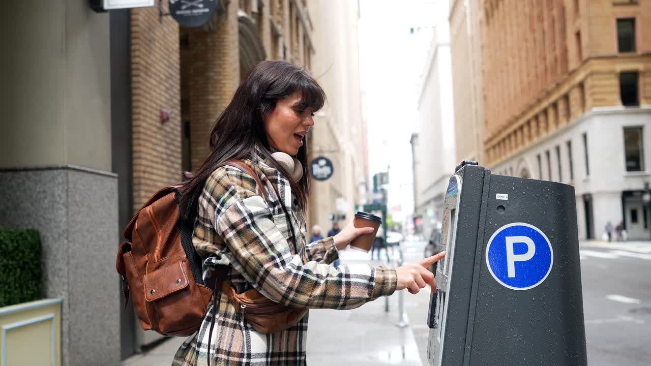 Joven pagando el estacionamiento en un parquímetro de la ciudad