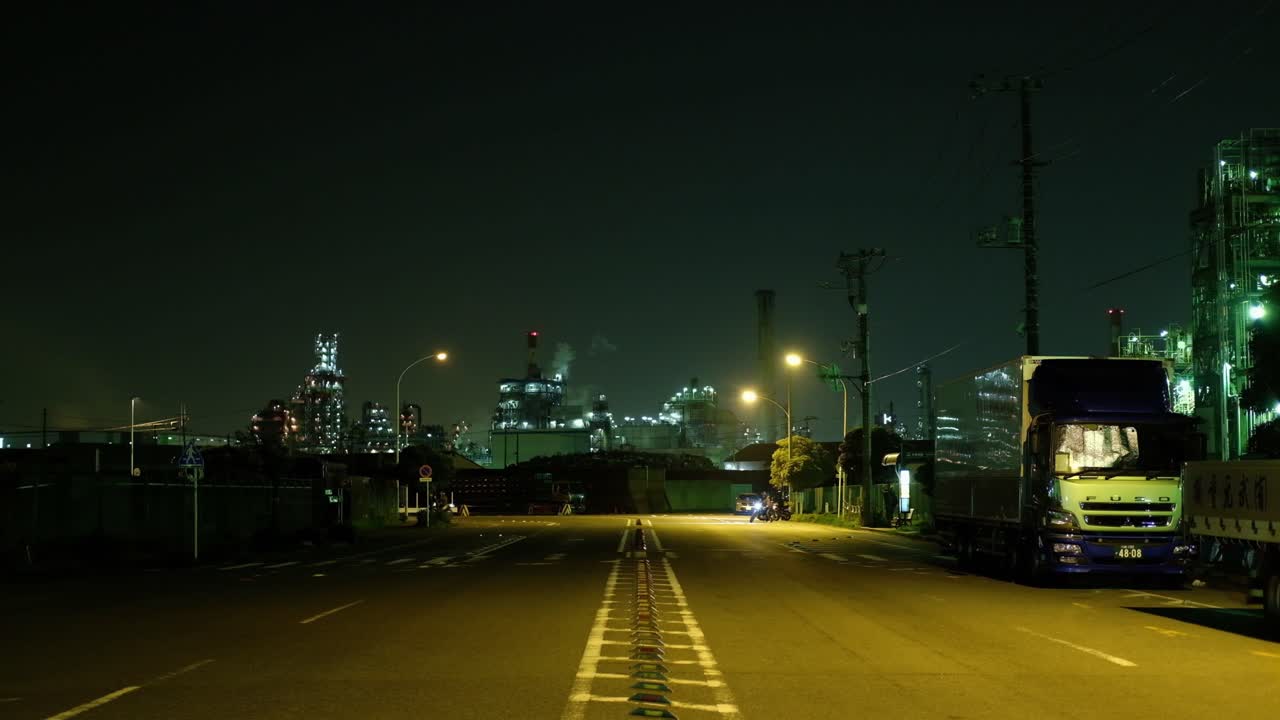 Shot of an industrial area at night, with bikers against the backdrop of factories in Kawasaki, Japan.