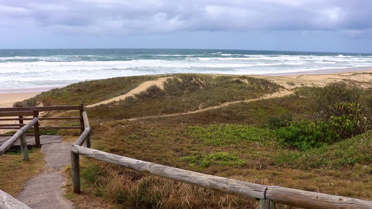 Wooden walkway entrance to tropical beach on a cloudy day in Sunshine coast Australia