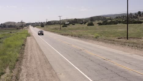 pick-up truck driving along american country road, aerial remote rural setting
