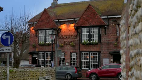 a traditional old english village pub in east sussex, as evening sets in