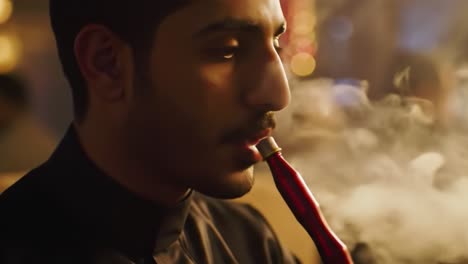 a moment of reflection: enjoying the last puff from a hookah in a lively atmosphere surrounded by friends and laughter