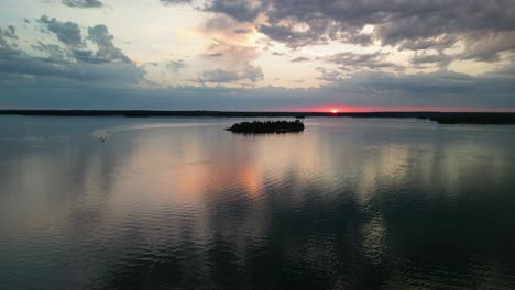 Vista-Aérea-Del-Barco-Chris-Craft-En-Aguas-Tranquilas-Al-Atardecer,-Islas-Les-Cheneaux,-Michigan