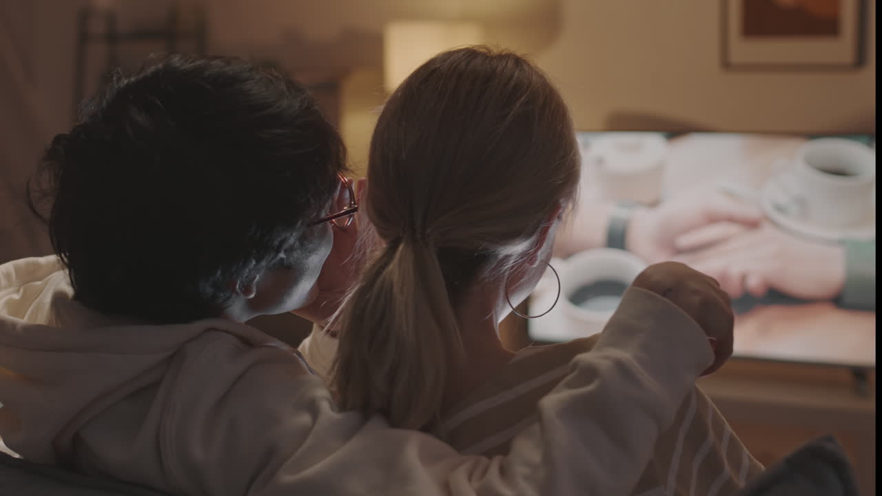 Couple Watching Romantic Movie and Whispering