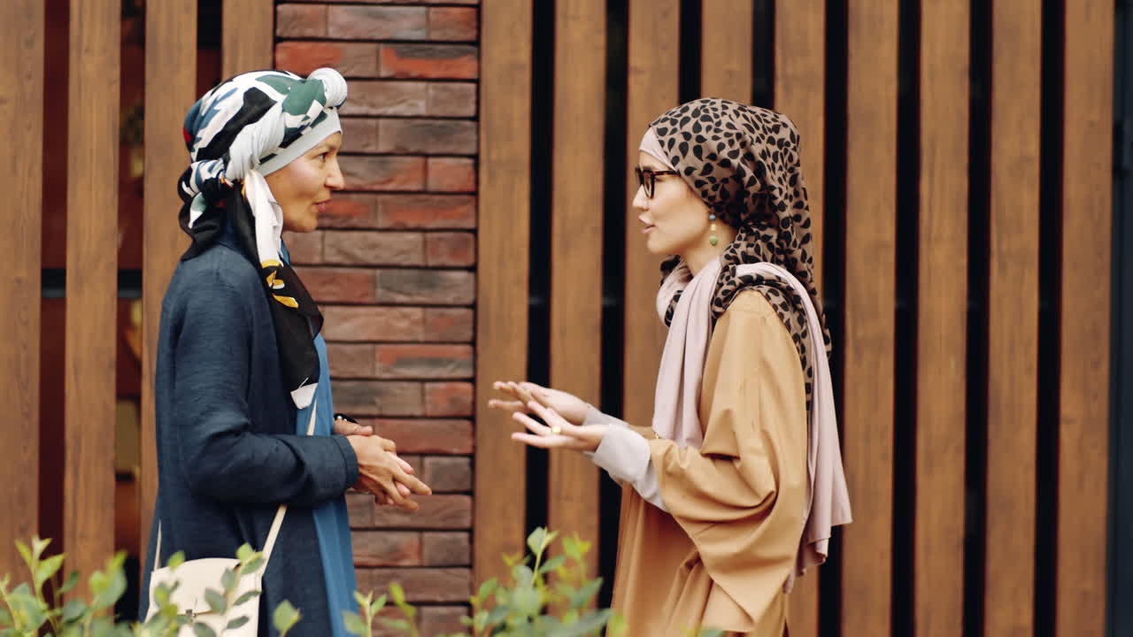 이슬람 여성들이 건물을 짓고 이야기하고 있습니다.