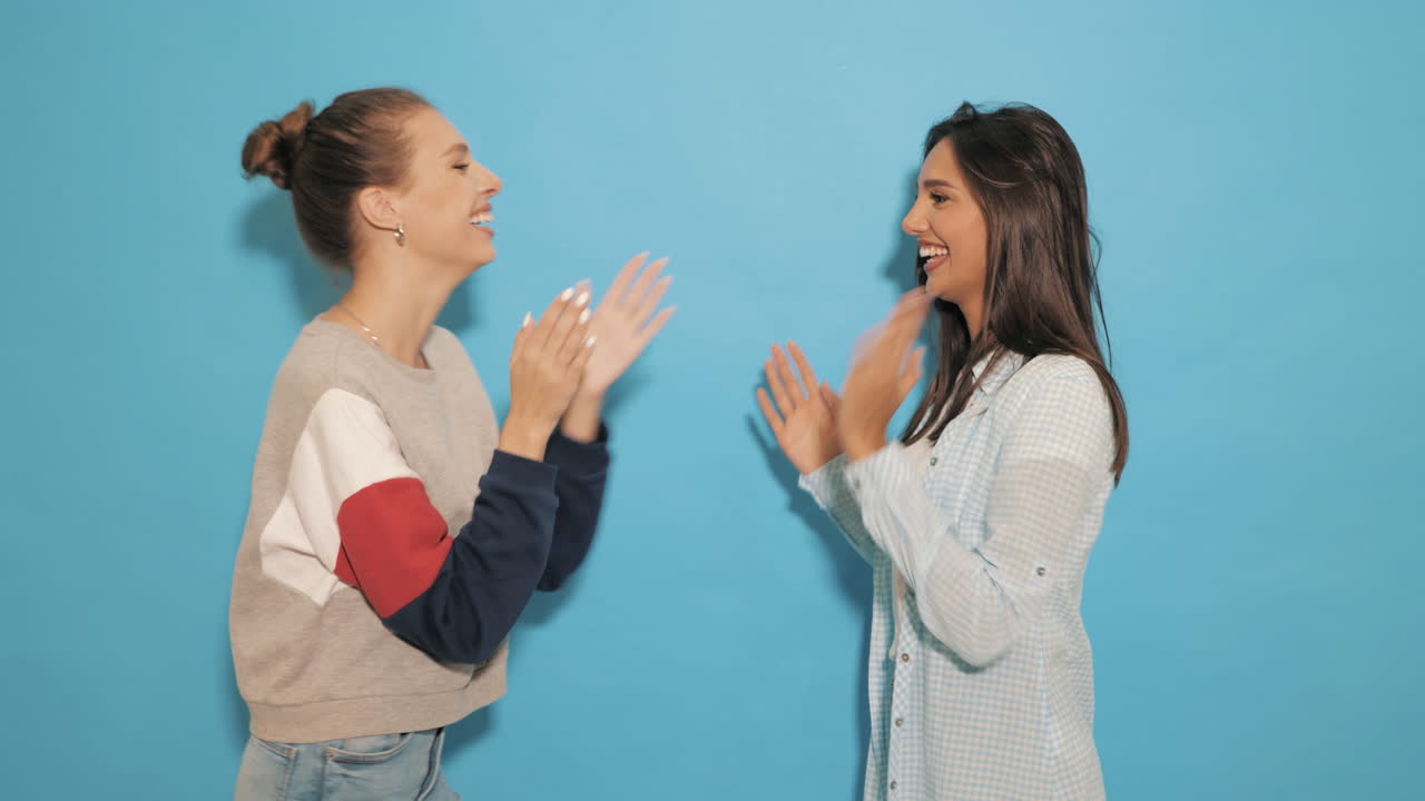 두 명의 행복한 여성들이 박수를 치고 있습니다.