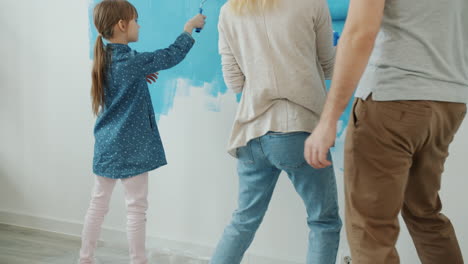 family painting a wall blue