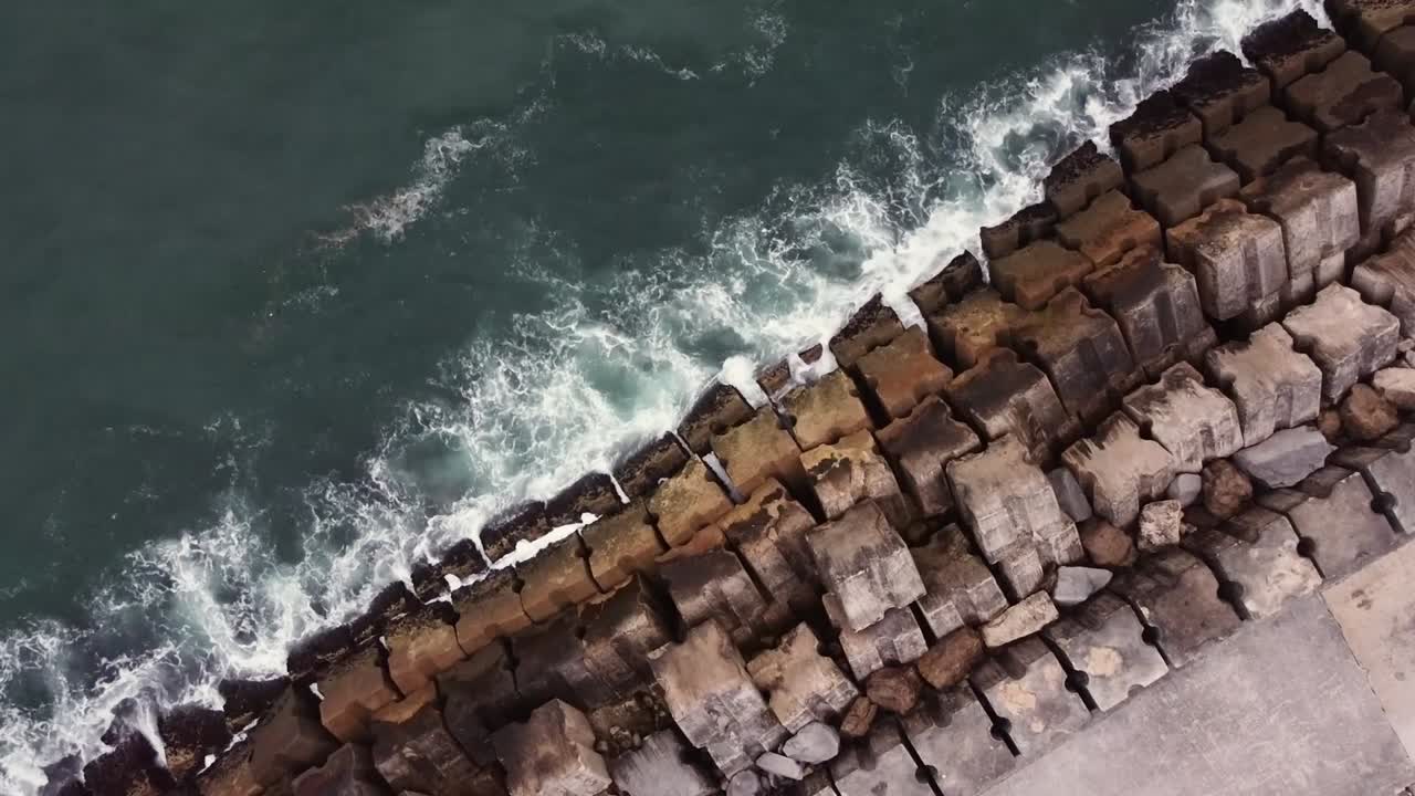 Droneskud ovenfra: Bølger rammer molen