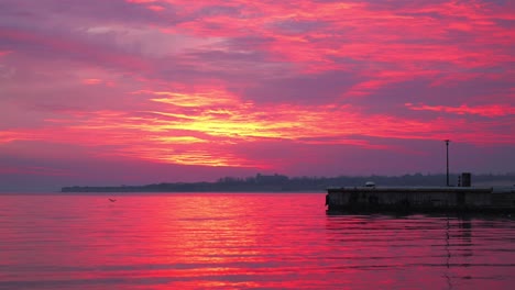 los hermosos colores rojos de la puesta de sol sobre las olas de bulgaria - amplio