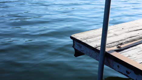 el muelle de madera se balancea suavemente sobre el tranquilo agua azul.