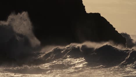 huge ocean waves roll and crash into a rocky shore in slow motion 1