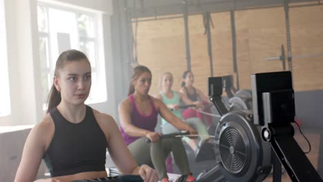 Konzentrierte,-Unveränderte,-Vielfältige-Frauen,-Die-In-Zeitlupe-Auf-Rudergeräten-Im-Fitnessstudio-Trainieren