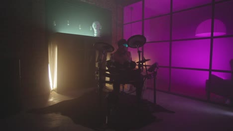 drummer with led glasses performing on electronic drums in neon lit room