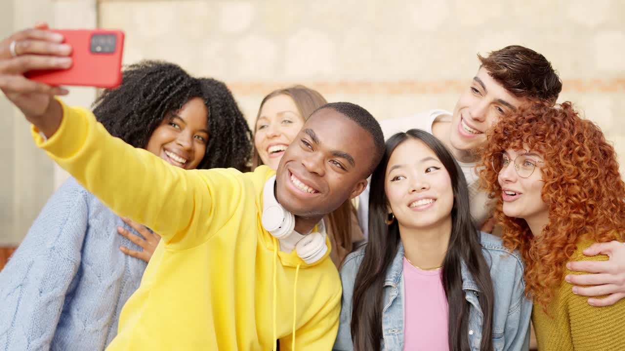 African man taking a selfie with multi-ethnic friends outdoors