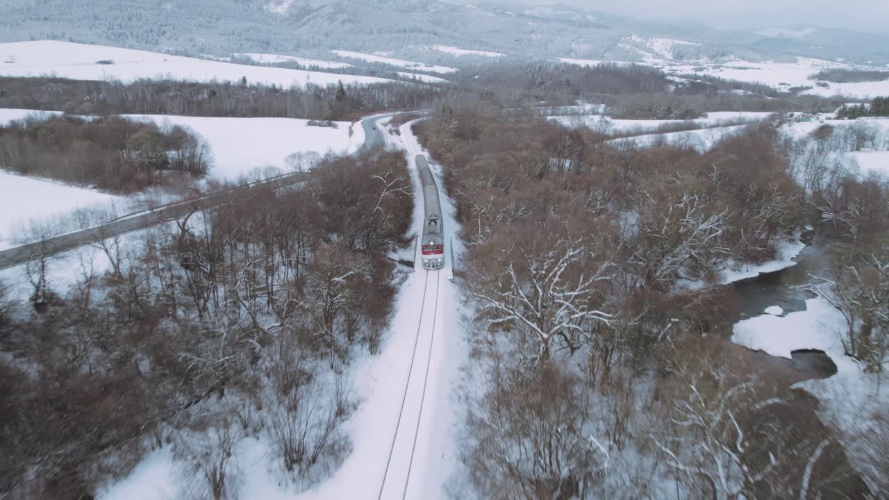 tren interurbano de pasajeros moviéndose en el paisaje invernal - vista aérea