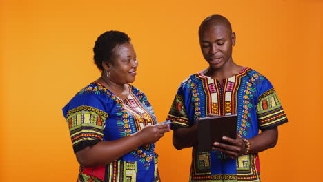 una pareja afroamericana comprando ropa a la venta con pago en la web,