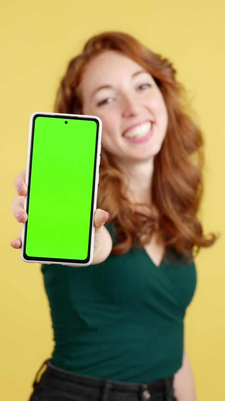 Woman showing a smartphone with a green screen
