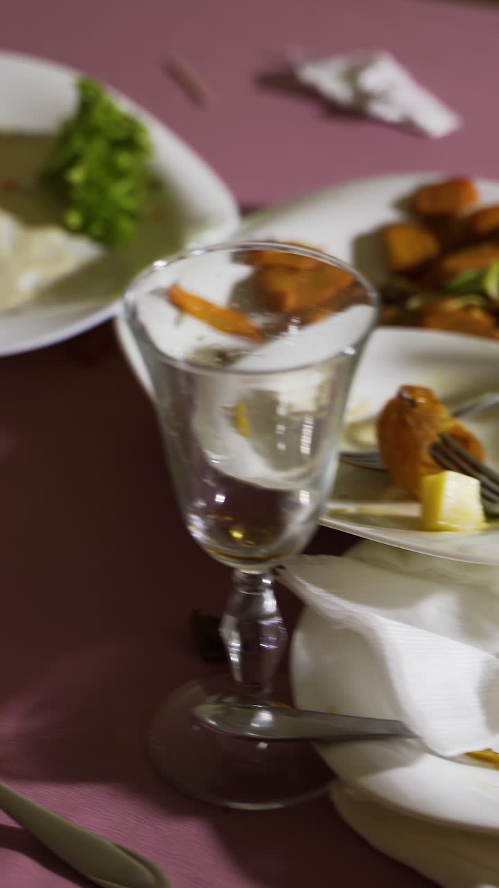 The leftover food and dirty dishes on the restaurant table. Vertical video