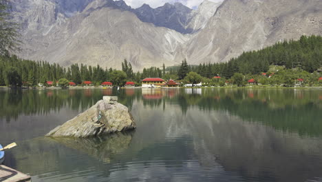 shangrila lake in skardu, pakistan with clear reflections of mountains and trees on calm water, stunning alpine retreat nestled in nature