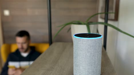 young man asks smart home speaker with assistant to play music, static