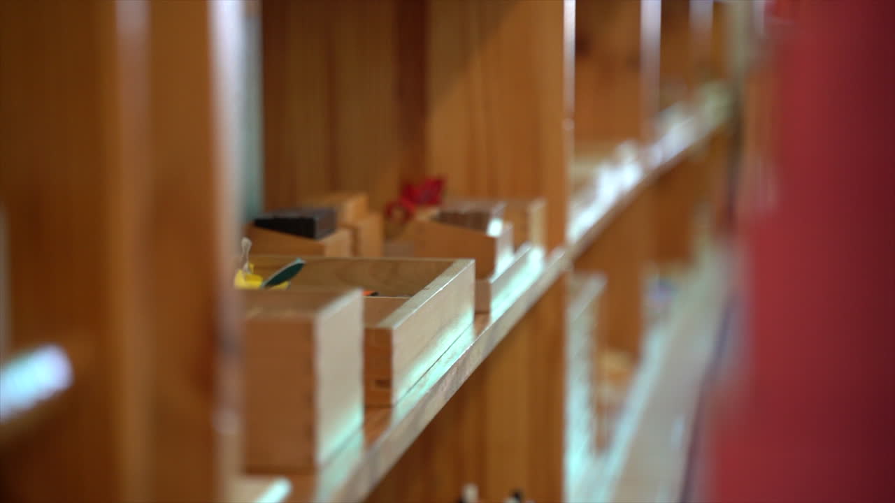 Panning shot of Montesorri School Bookshelf with toys on it