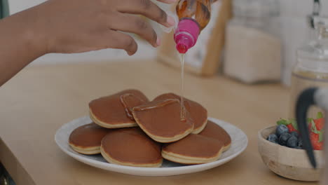 pouring honey on pancakes