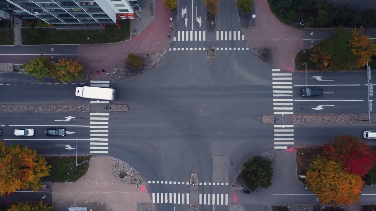Bright autumn trees line city street intersection, seen from above