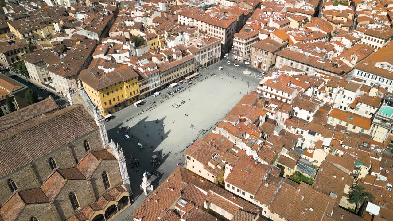 Aerial orbit around promenade front lawn of Basilica of Santa Croce in Florence Italy with long shadow
