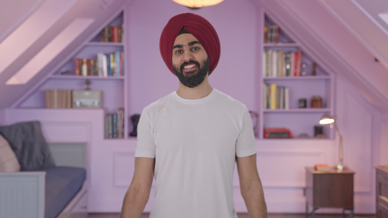 Uomo indiano Sikh felice che solleva manubri pesanti