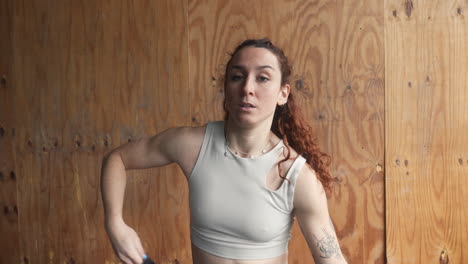 a determined red head woman removes her thermal shirt, revealing strength and determination before embarking on an intense workout