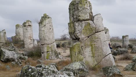 lonely woman sitting among stunning ancient rock formations in peace and calm