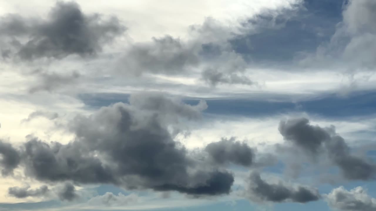 Beautiful layers of clouds moving past an airplane in the sky